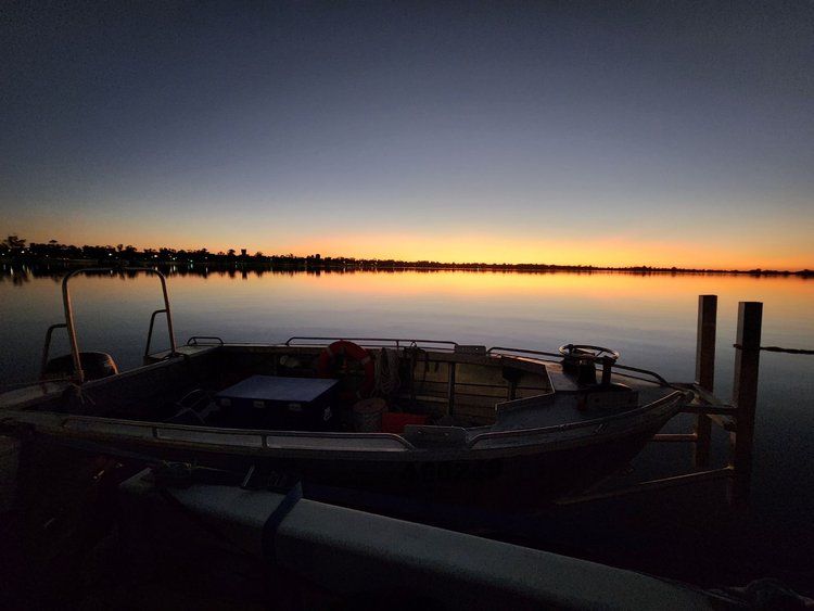 a boat is docked in the water at sunset