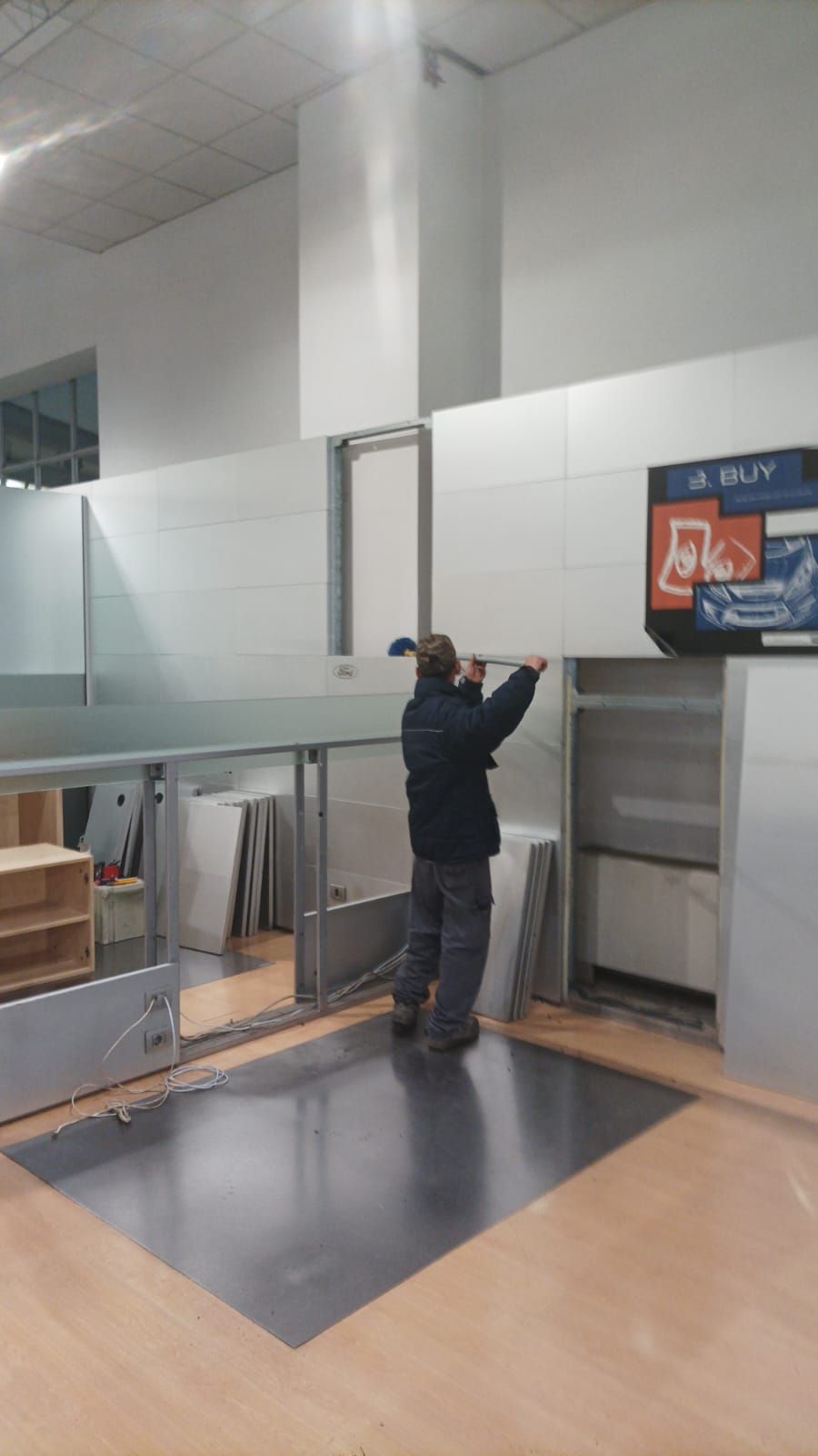 Una persona si protende verso un display a parete in una moderna hall interna.
