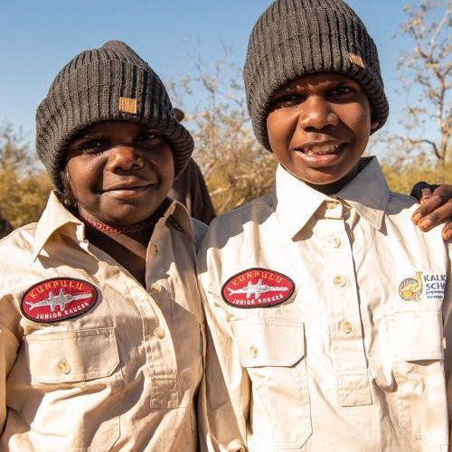 Two boys wearing beanies and shirts with a shark embroidered on them