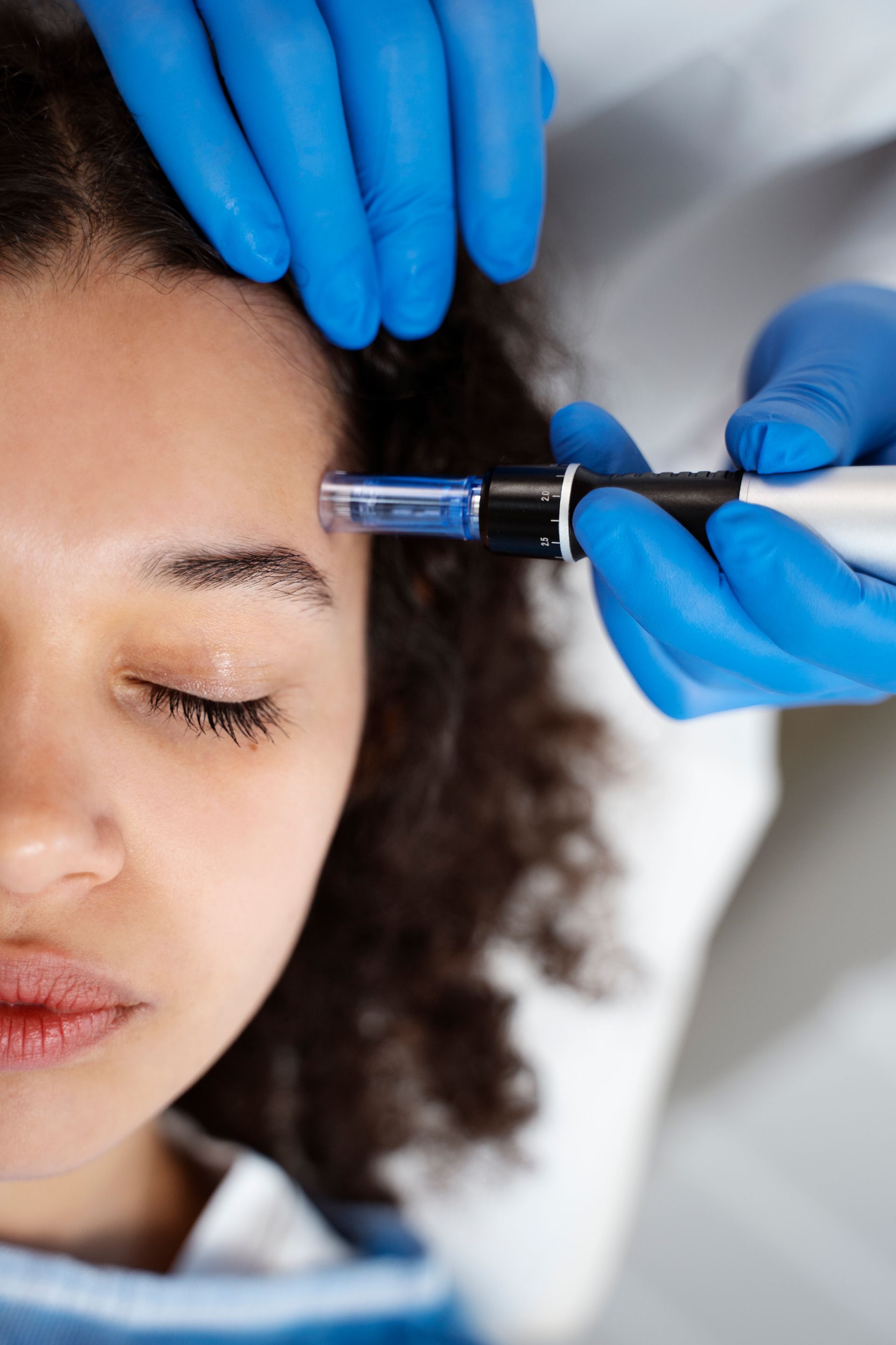 A woman is getting a botox injection in her forehead.