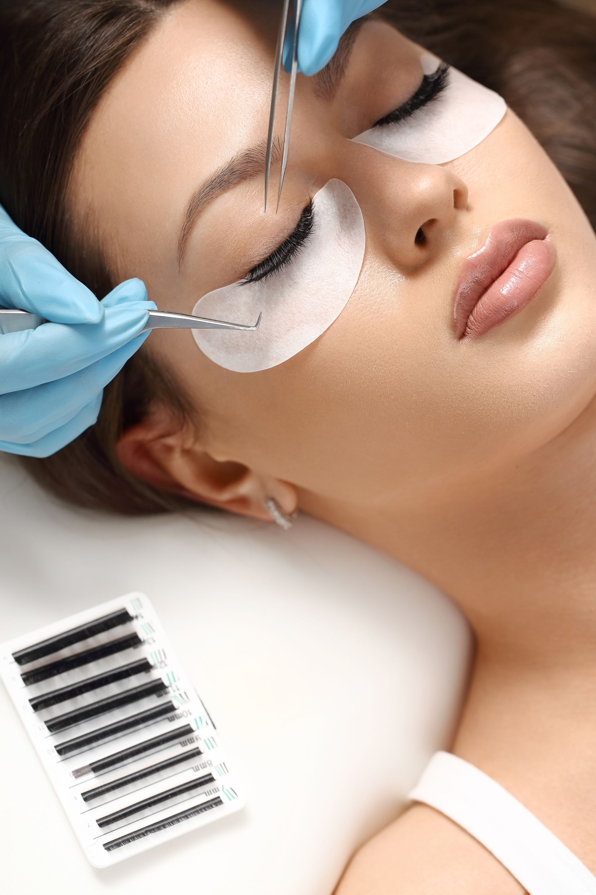 A woman is getting eyelash extensions in a beauty salon.