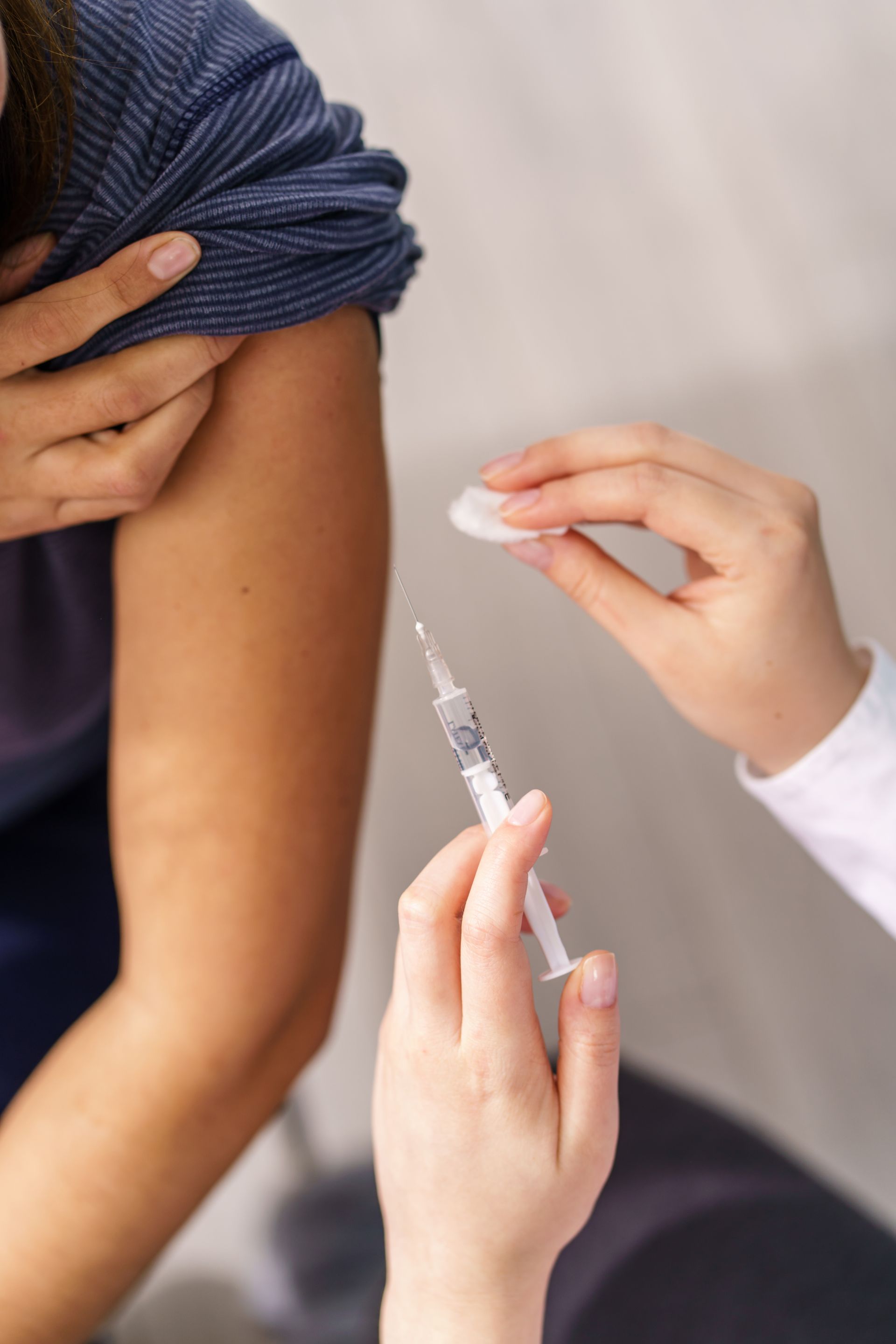 A woman is getting an injection in her arm.