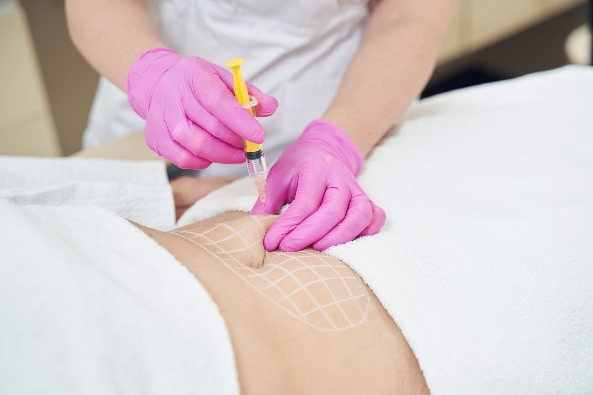 A woman is getting an injection in her stomach.