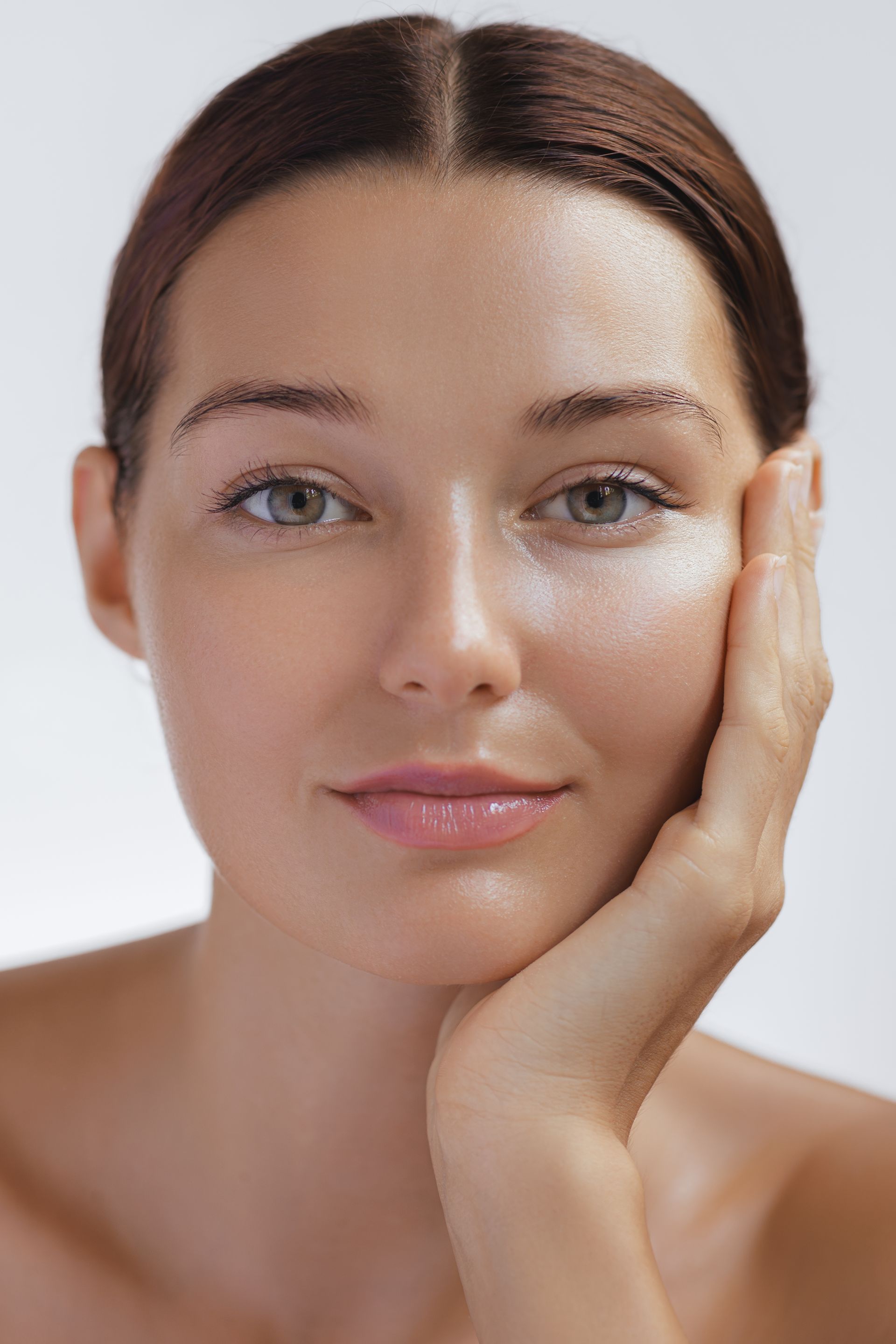 A close up of a woman 's face with her hand on her face.