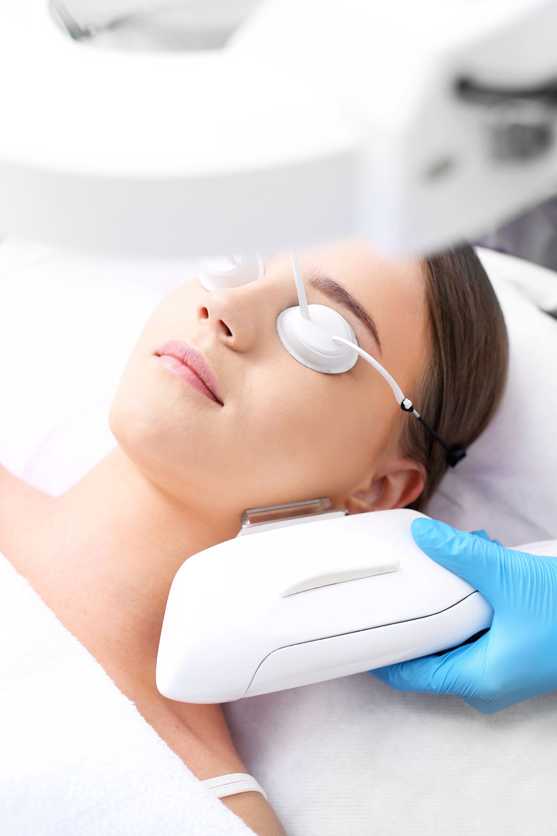A woman is getting a laser treatment on her face.