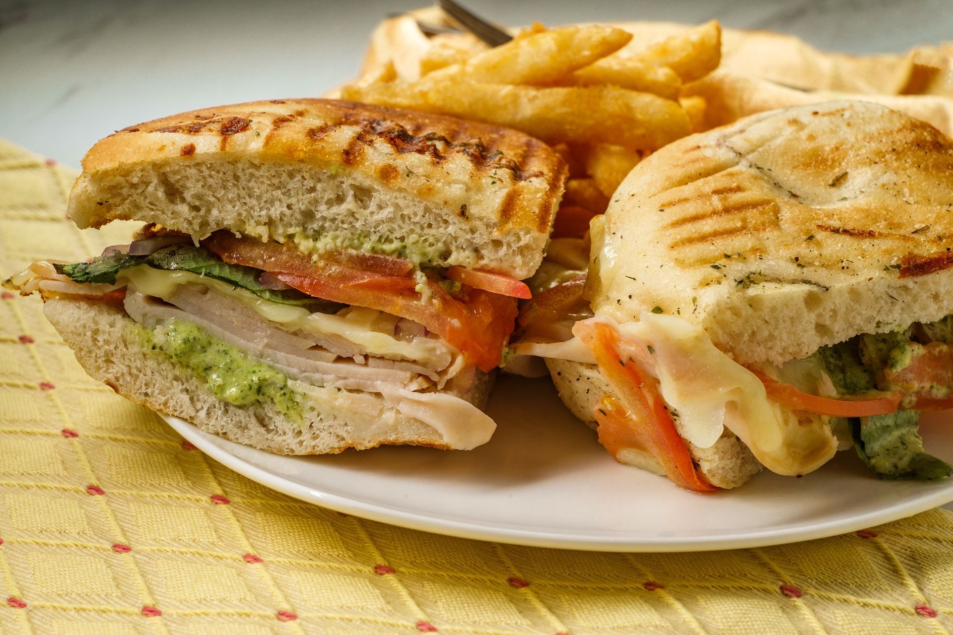A sandwich and french fries are on a white plate.