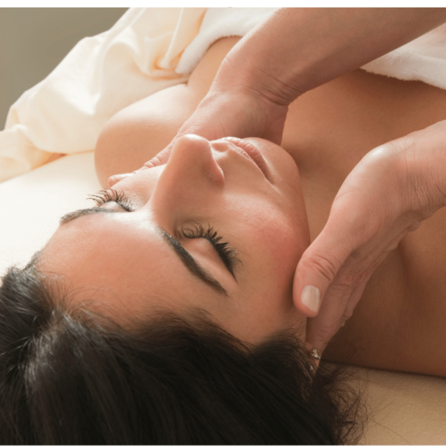 Hands massaging a person's face and neck; receiving clinical treatment at casey healing wellness