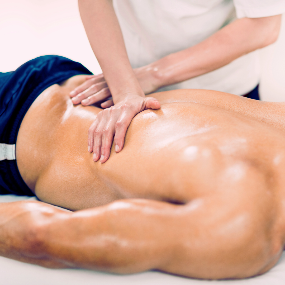Massage therapist giving a back massage to a client lying face down on a table