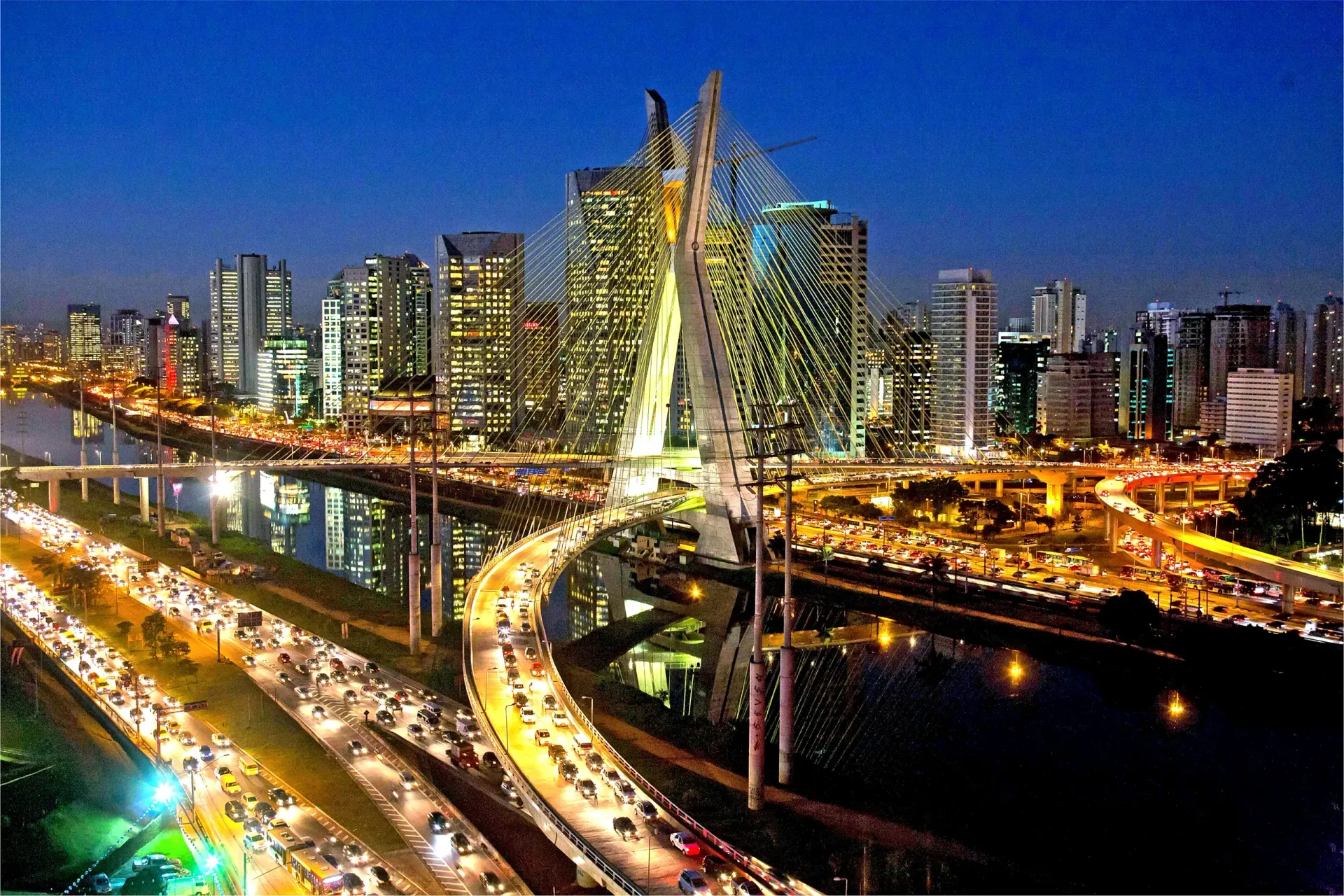 Ponte Estaiada e skyline de São Paulo iluminados ao anoitecer