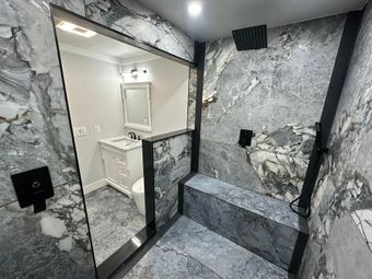 Bathroom with black and white patterned tile flooring and decorative ceiling. White walls and vanity.