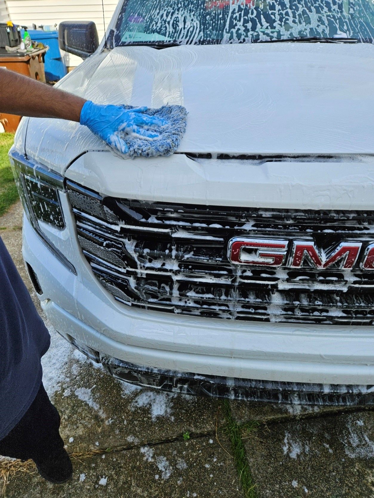 A Man Is Standing Next to A Blue Car - Parma, OH - Family First Car Care