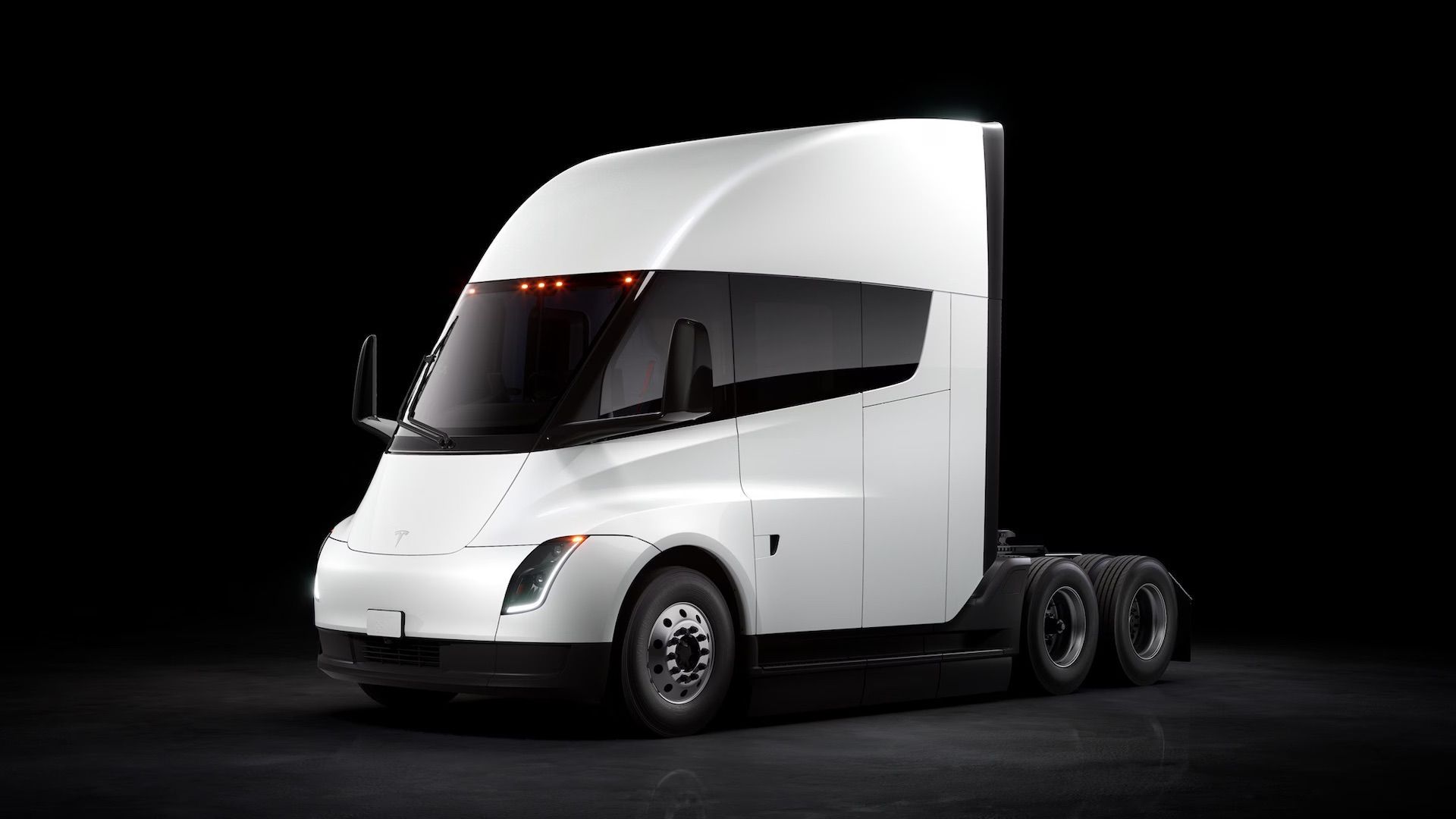 White semi-truck tractor cab on a black background, angled front-left view