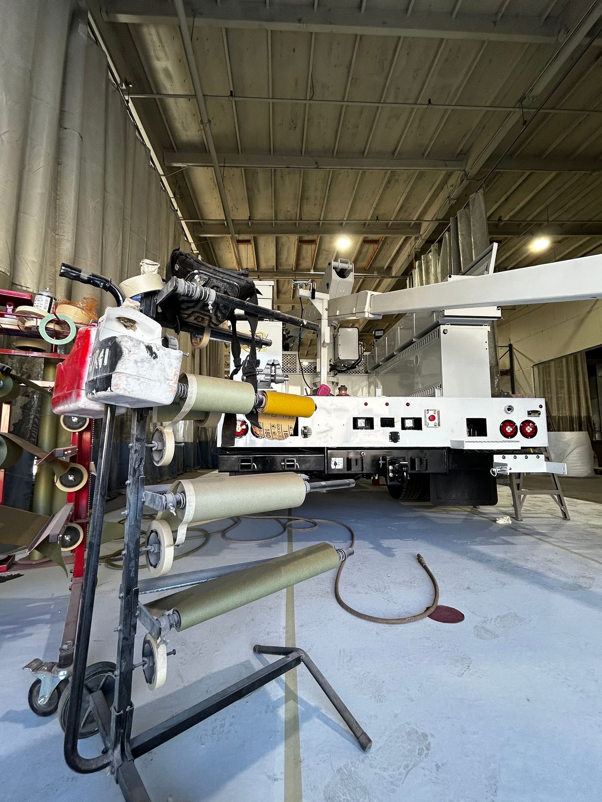 Industrial workshop with a white machine and exposed tubing on a concrete floor
