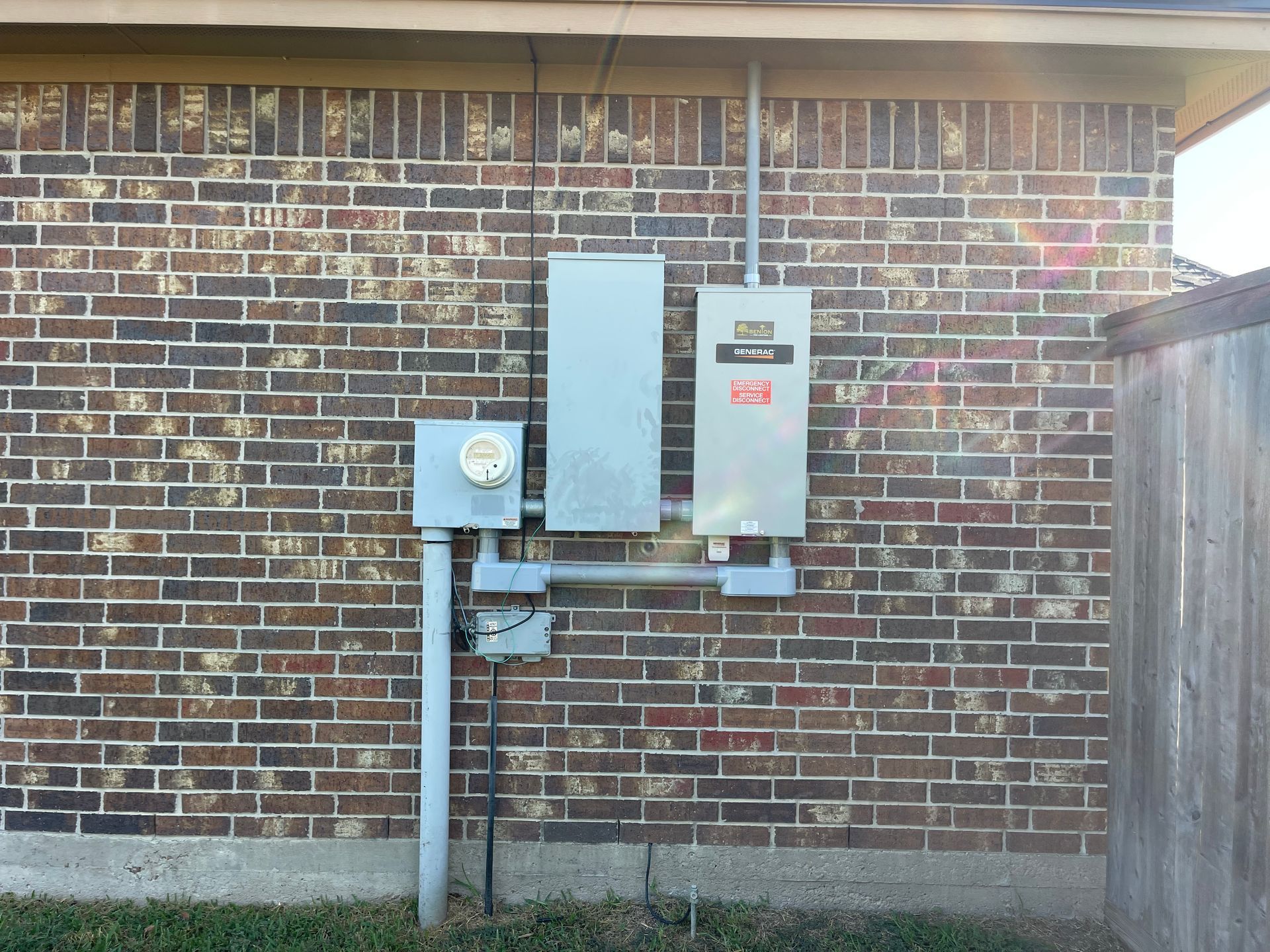 Electrical panel boxes mounted on a brick exterior wall.