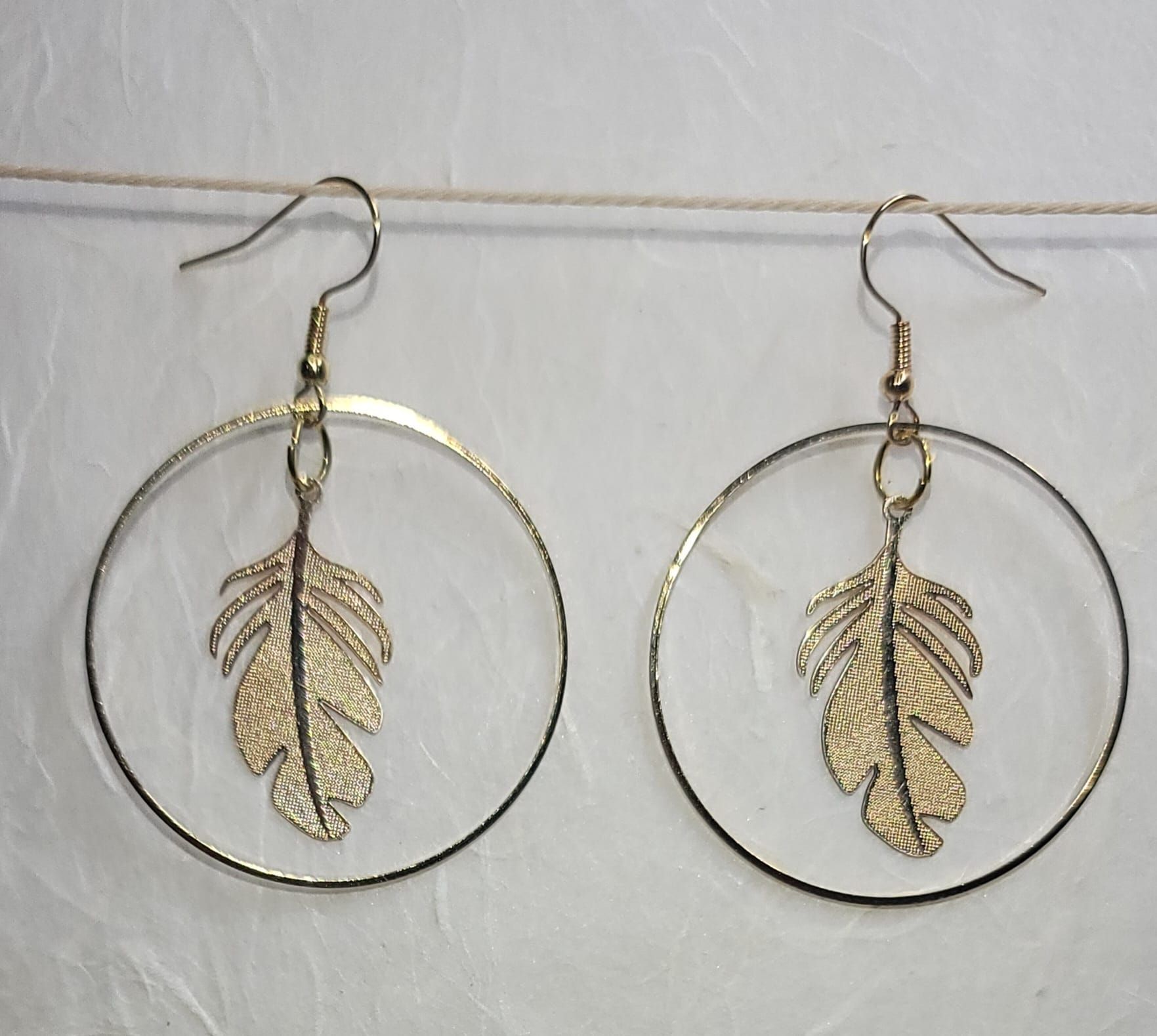 Tas Tas handmade brass leaf hoop earrings with gold-plated posts and dangling leaf charms