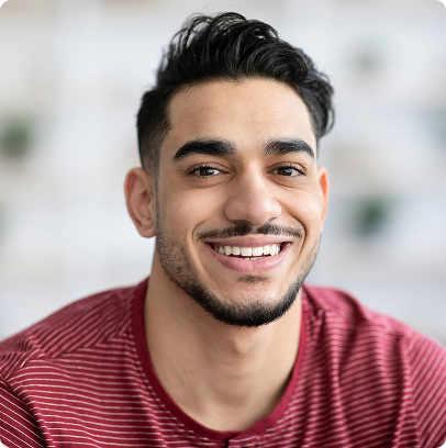 Smiling man in a red striped shirt against a softly blurred background