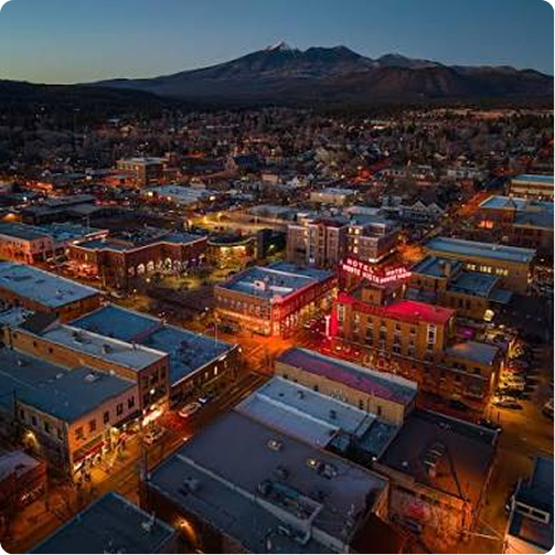 Aerial twilight view of a lit downtown with mountains in the background