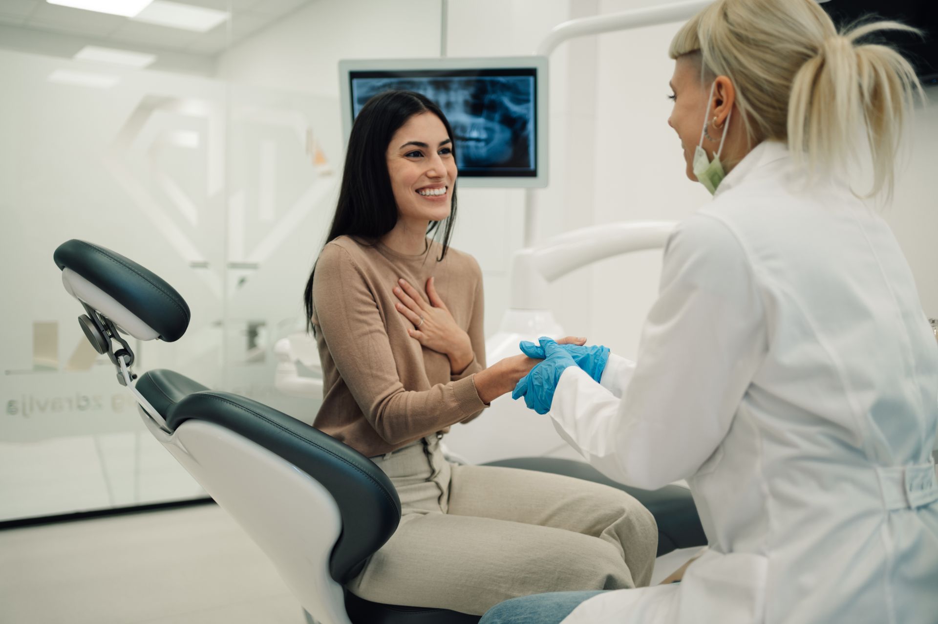 Smiling patient greeting her family dentistry provider before a dental exam