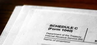 Close-up of a tax form labeled “Schedule C (Form 1040)” on white paper.