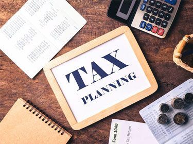 Tax planning concept: board with text, documents, calculator, coins.