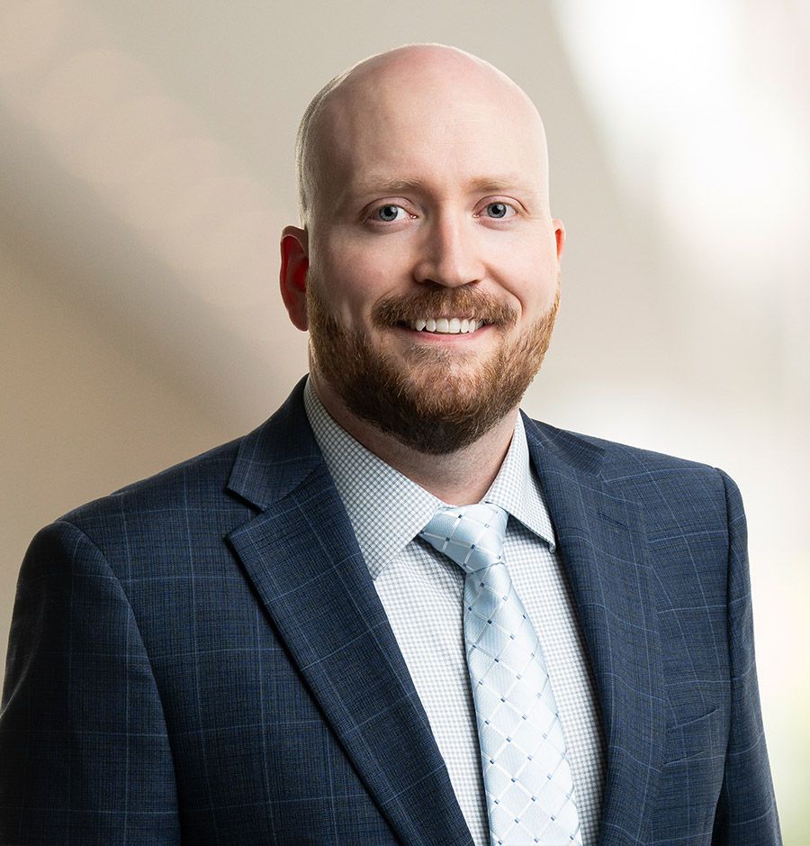 a man in a suit and red tie is smiling for the camera .