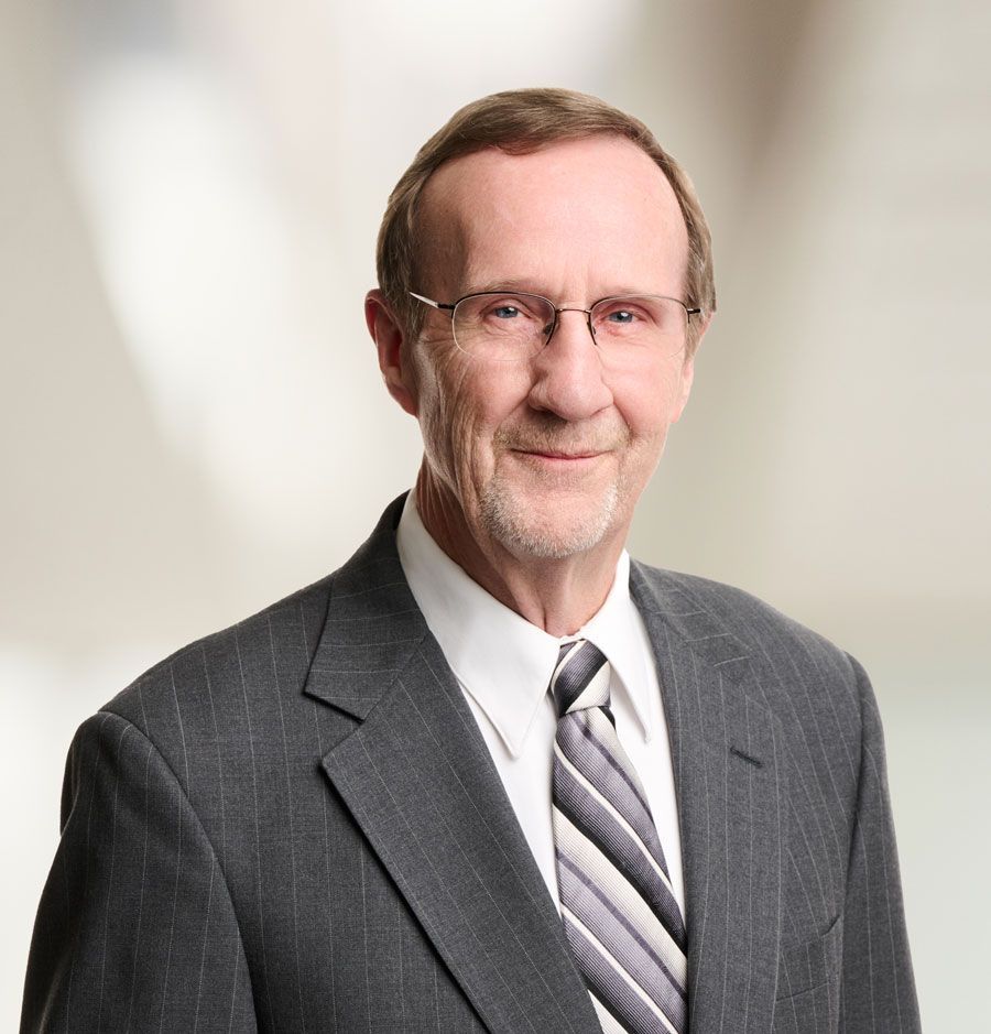 a man in a suit and red tie is smiling for the camera .