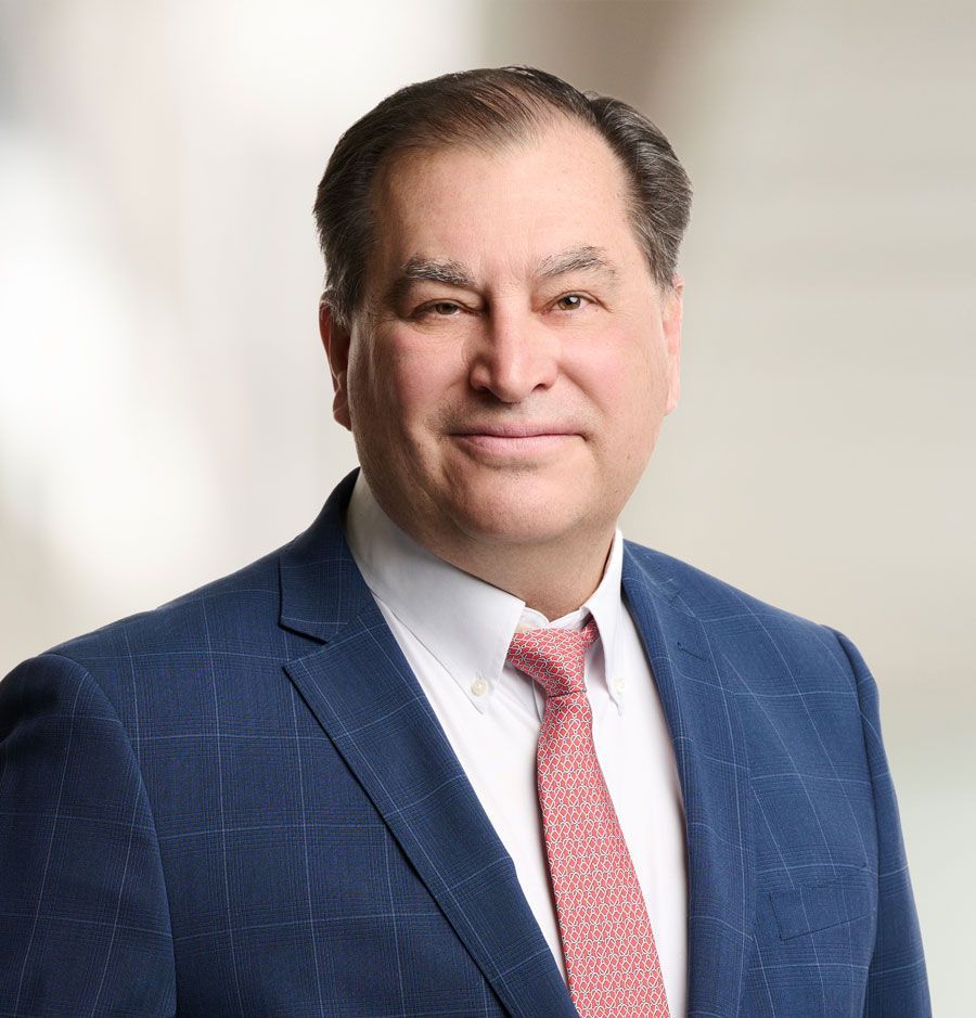 a man in a suit and red tie is smiling for the camera .