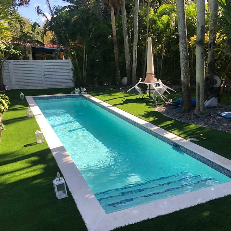A large swimming pool surrounded by trees and grass