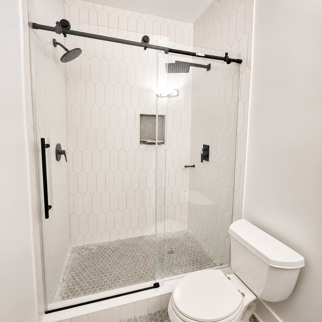 Bright marble bathroom with glass shower, freestanding tub, and large window