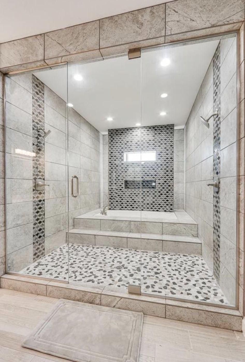 Glass-enclosed tiled spa shower with mosaic floor, step-up bench, and recessed ceiling lights