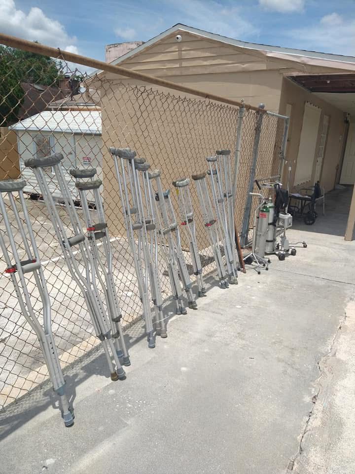 Metal folding carts lined up along a chain-link fence beside a beige house driveway.