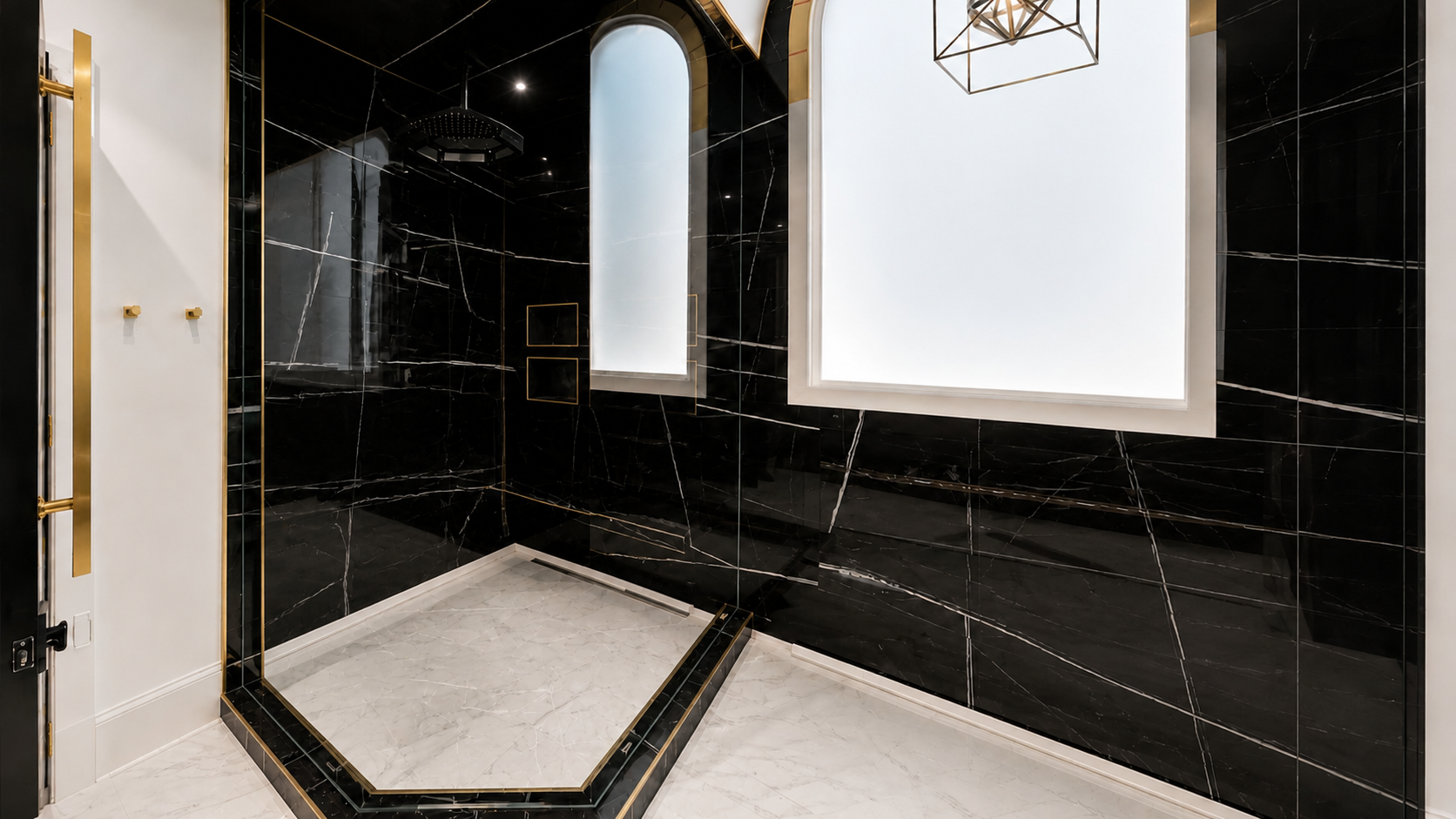 Modern black-tiled shower with white trim, glass enclosure, and hexagonal white floor tiles
