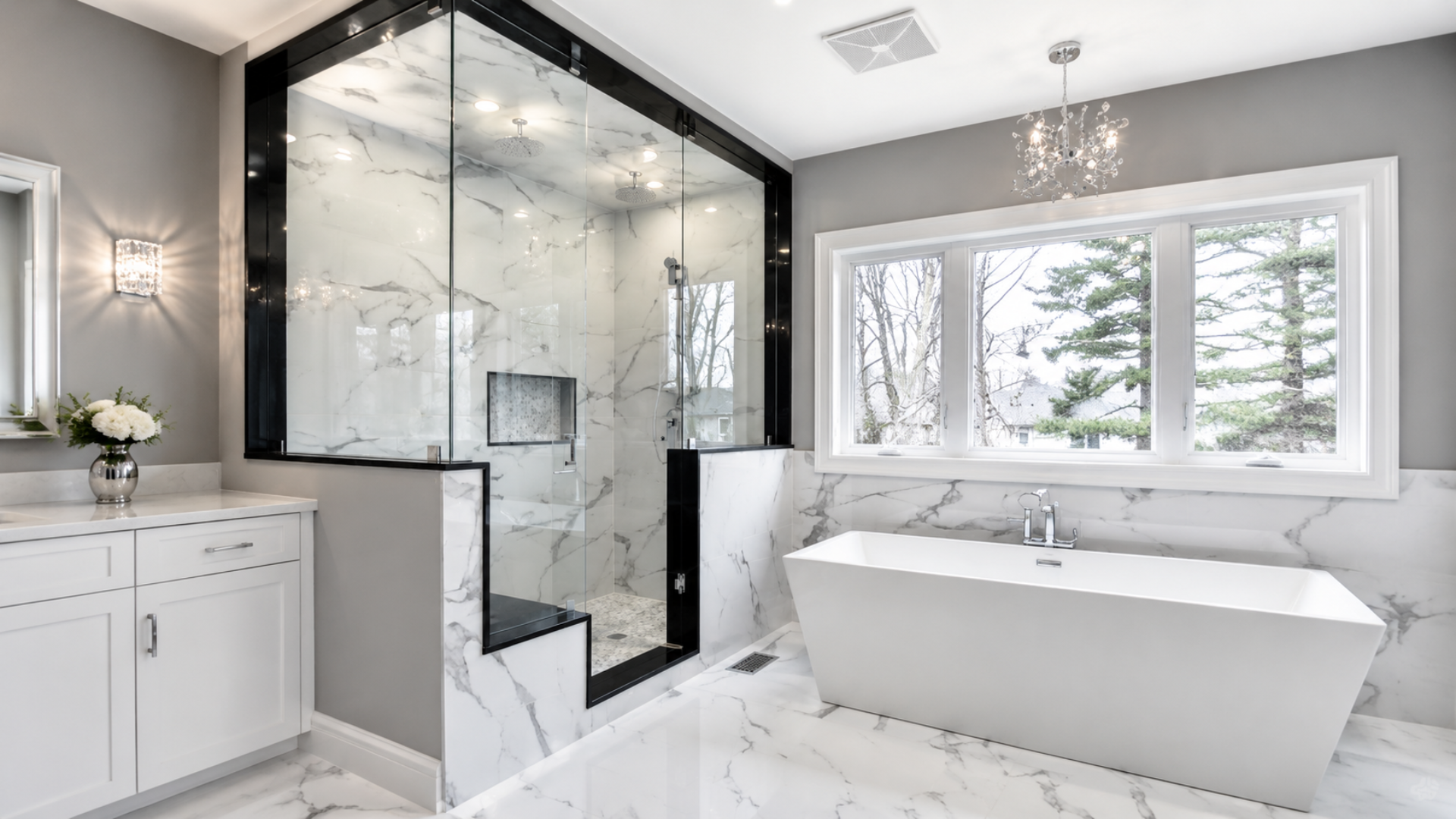 Modern white bathroom with glass shower enclosure, freestanding tub, and large window.