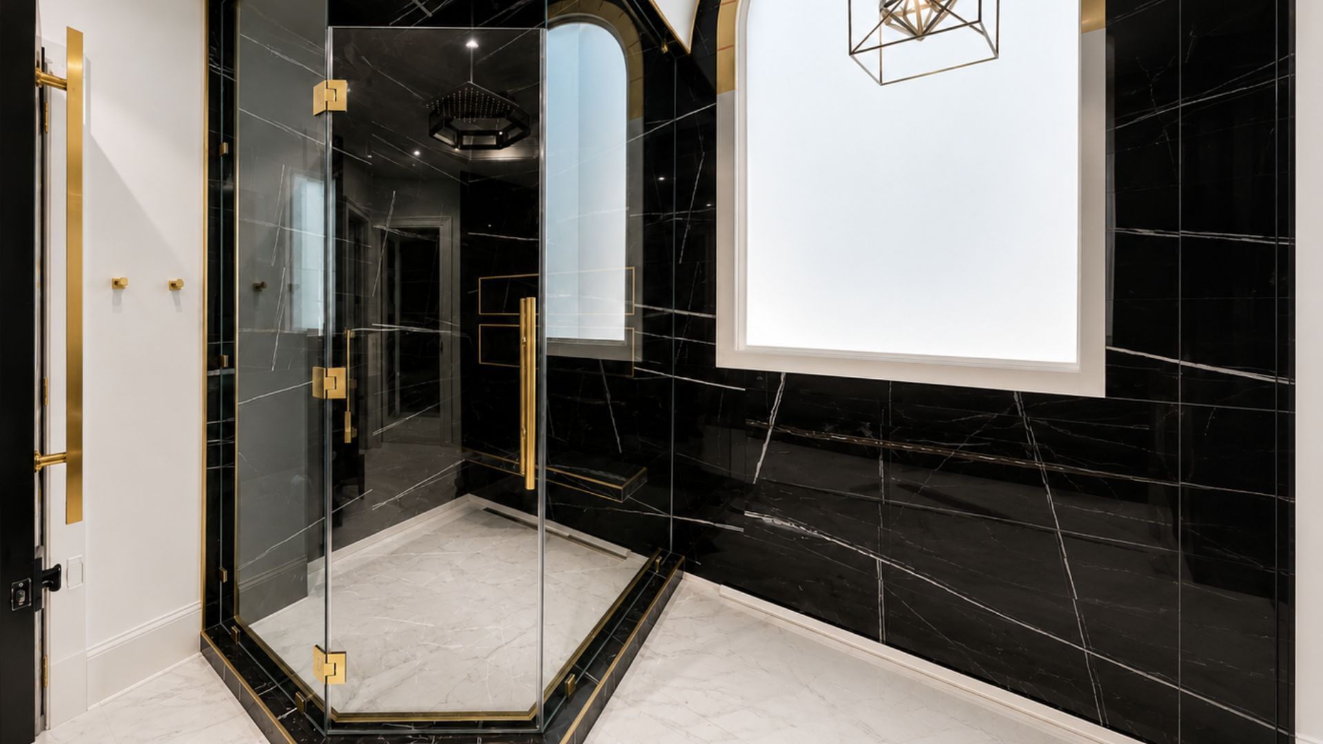 Modern bathroom with black tiled walls, glass shower enclosure, and white vanity mirror