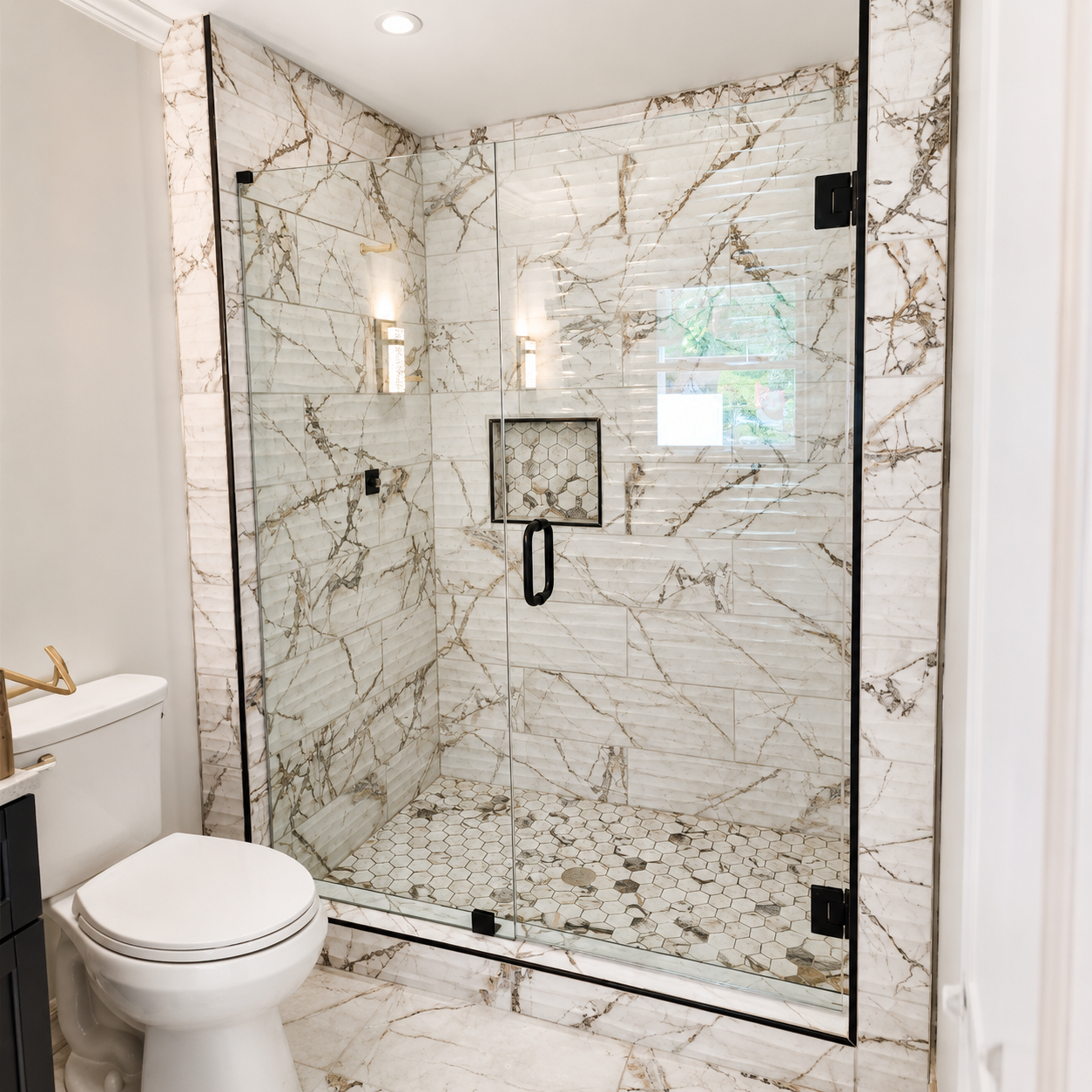 Modern bathroom with a glass-enclosed shower, white marble walls, and a toilet in the foreground