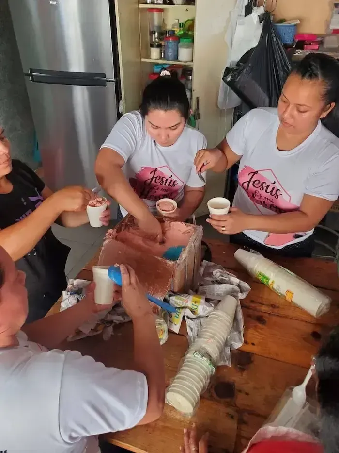 People around a wooden table packing items into containers in a kitchen