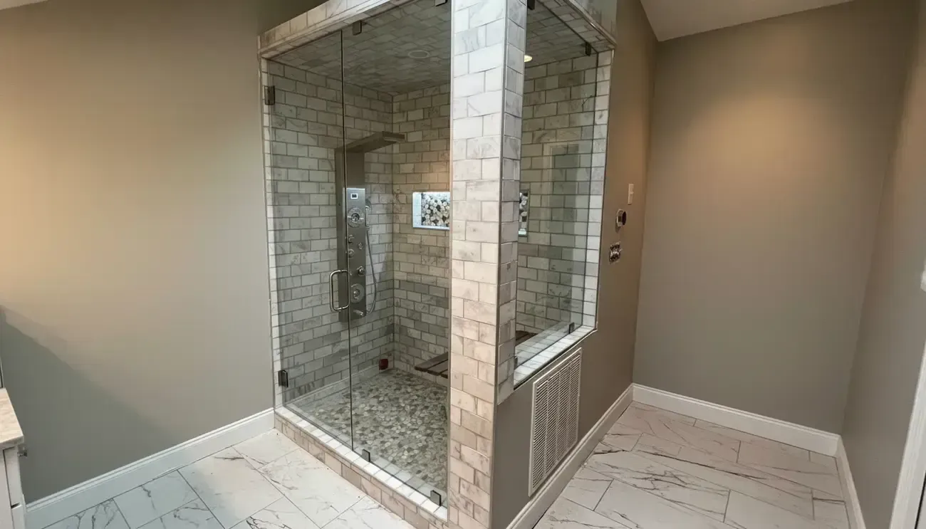 Bathroom with a tiled walk-in shower, open doorway, and beige walls