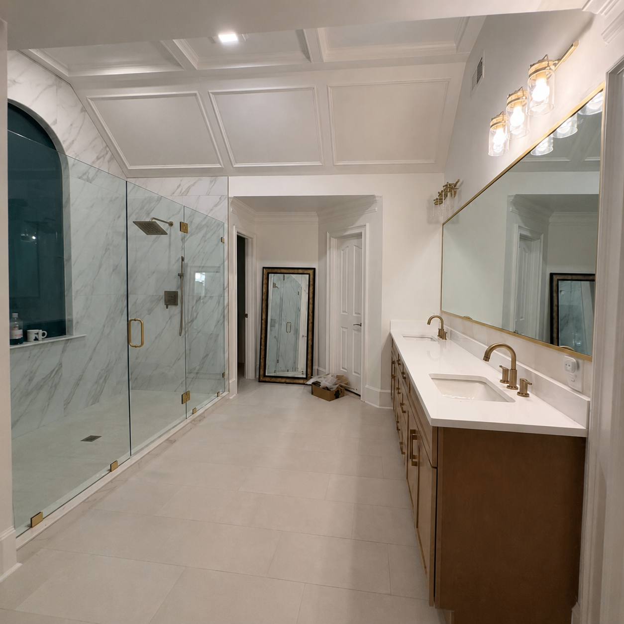 Modern white bathroom with glass shower stalls, long vanity, and mirrors along one wall