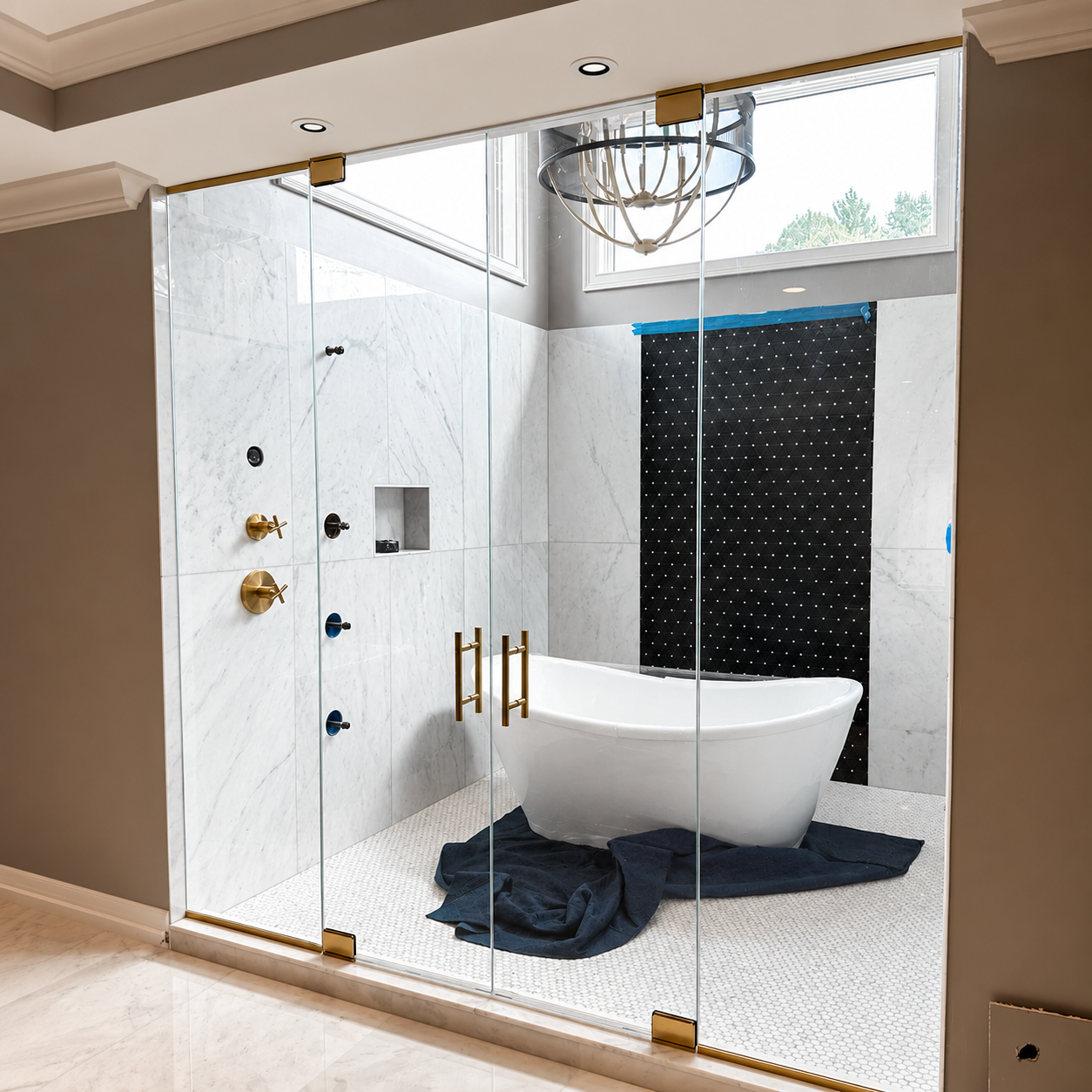 Bright marble bathroom with glass shower, freestanding tub, and large window