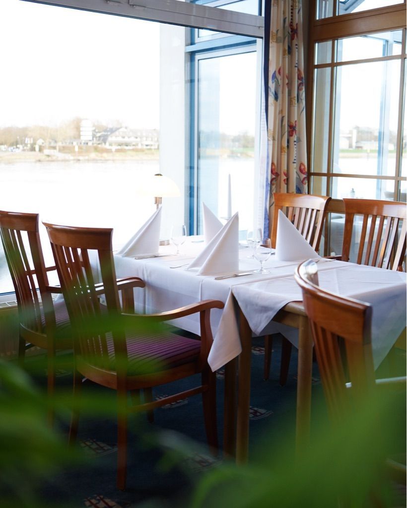 Ein Tisch und Stühle in einem Restaurant mit Blick auf das Wasser