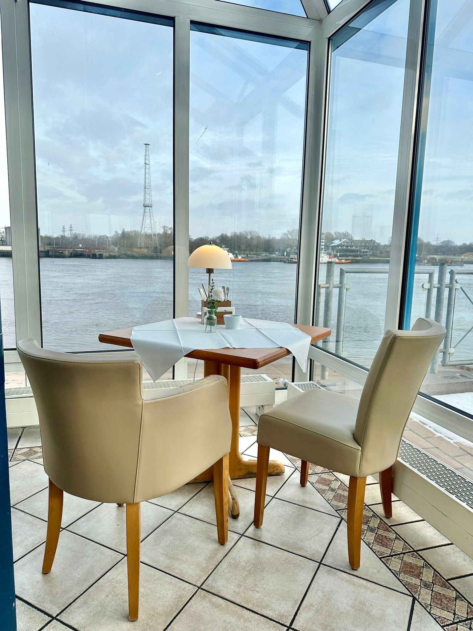 Ein Tisch und Stühle in einem Zimmer mit Blick aufs Wasser.