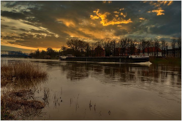 Ein Boot treibt bei Sonnenuntergang auf einem Fluss.
