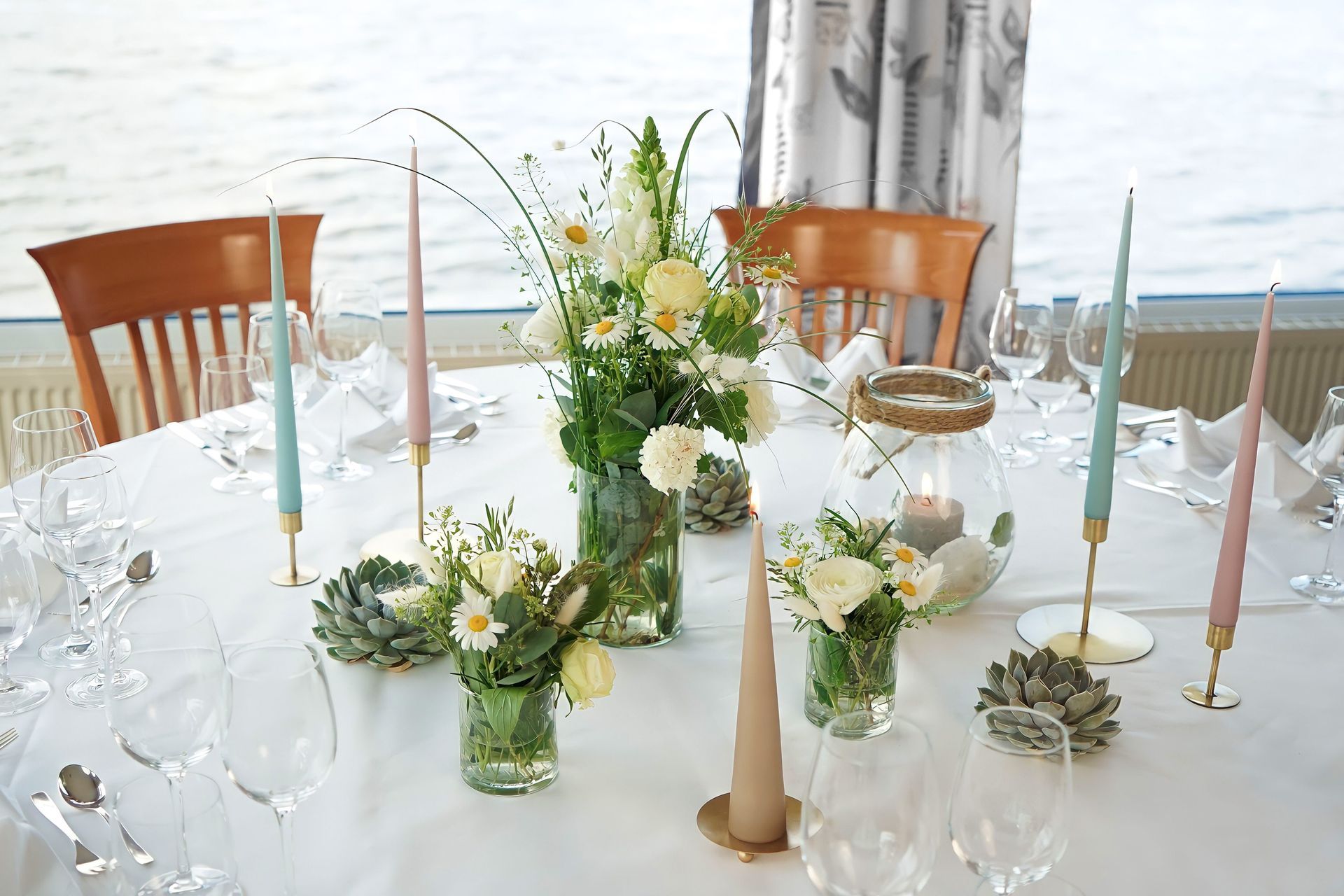 Ein Tisch mit einer Blumenvase und Kerzen darauf.