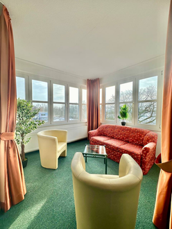 Ein Wohnzimmer mit einer Couch, Stühlen und einem Tisch.