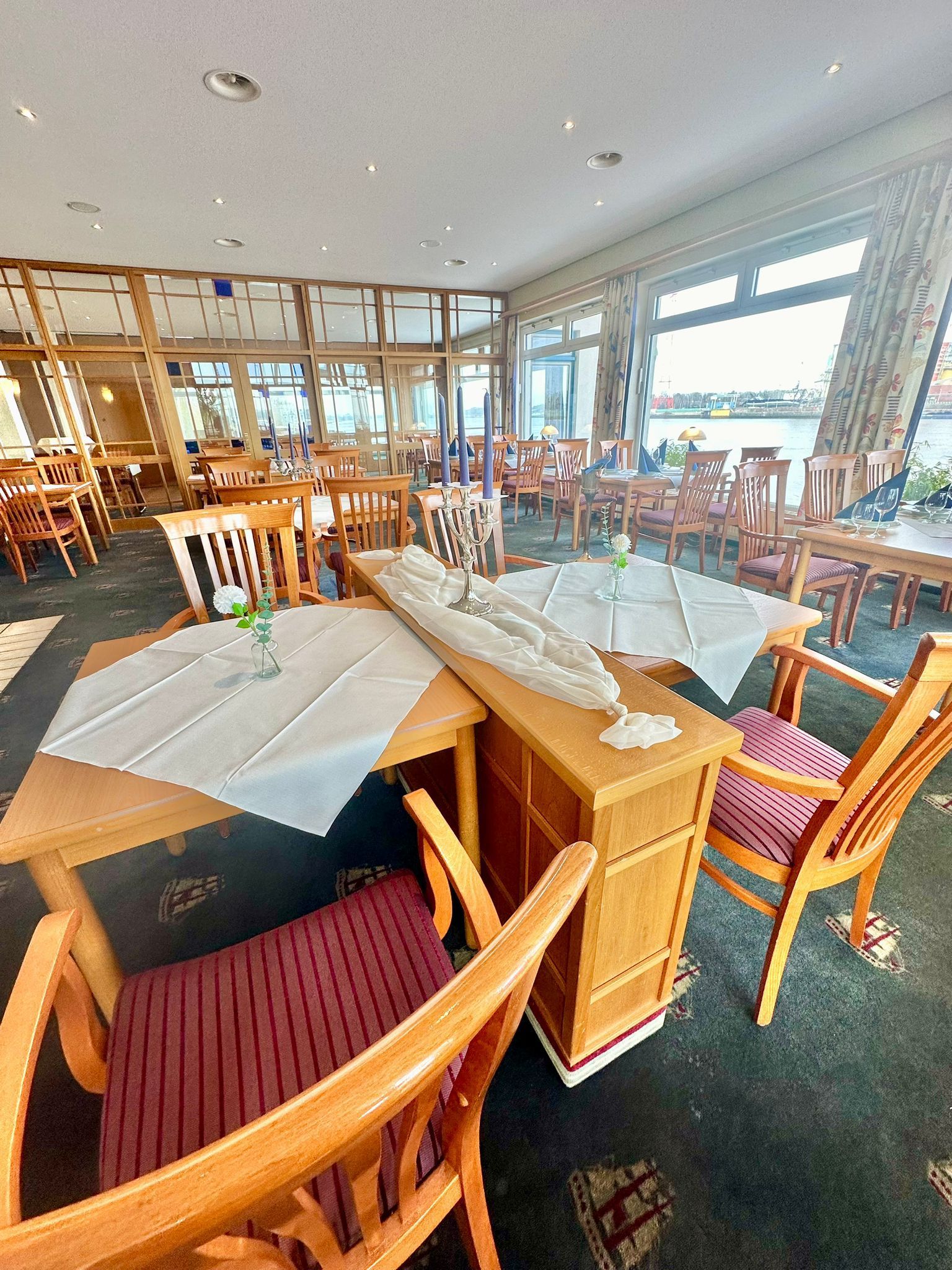 Ein Restaurant mit Tischen und Stühlen und einem großen Fenster.