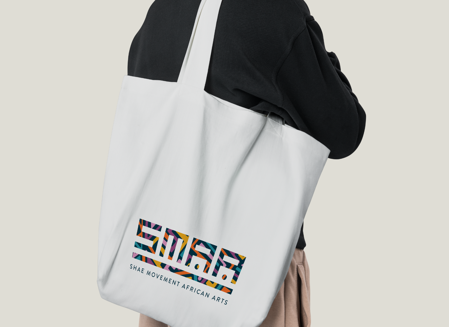 A person is carrying a white tote bag with the word smart on it.