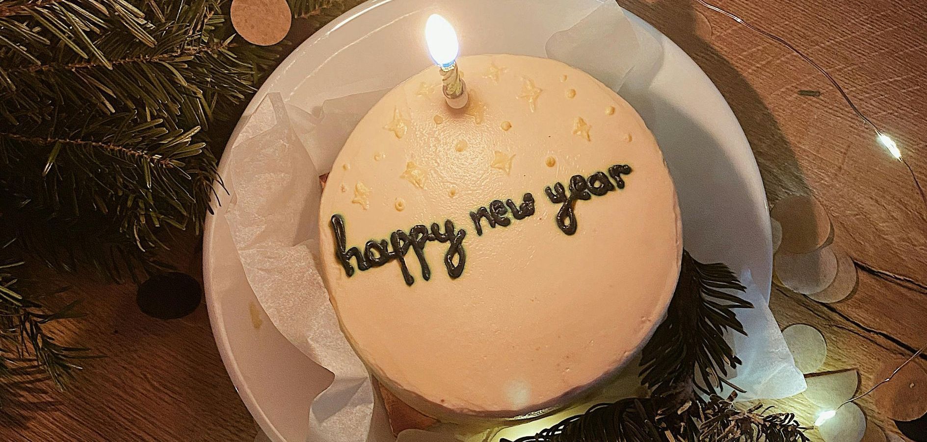 A cake with a candle on it that says happy new year