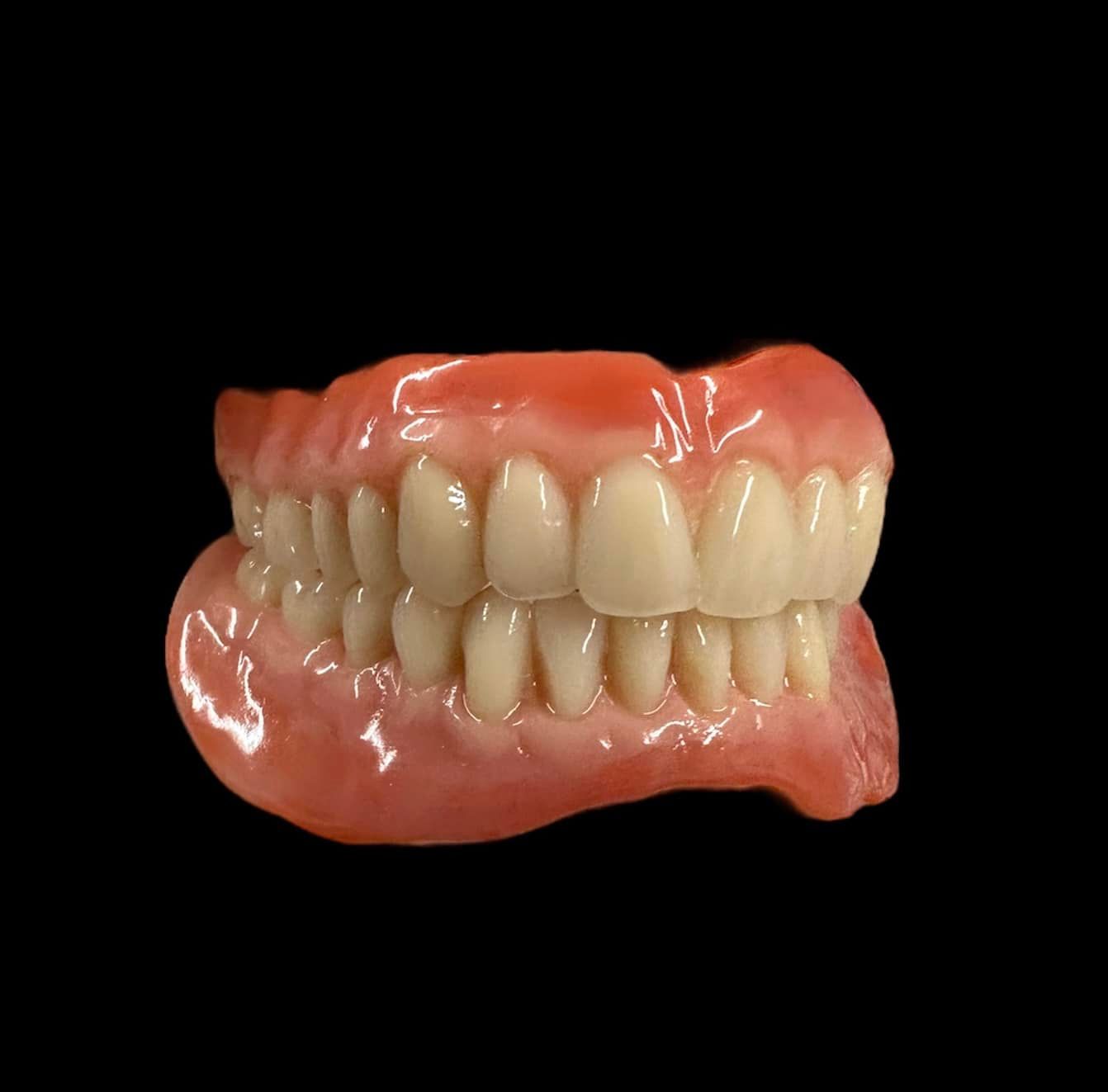 dentures being held by dental technician with rubber gloves