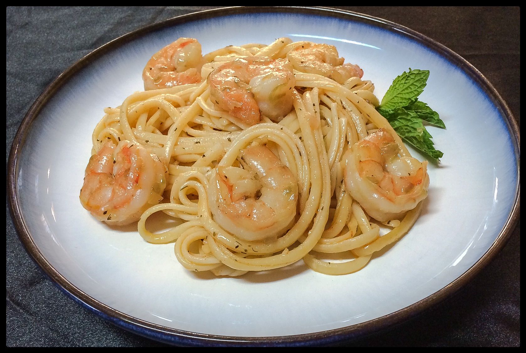 A white plate topped with spaghetti and shrimp