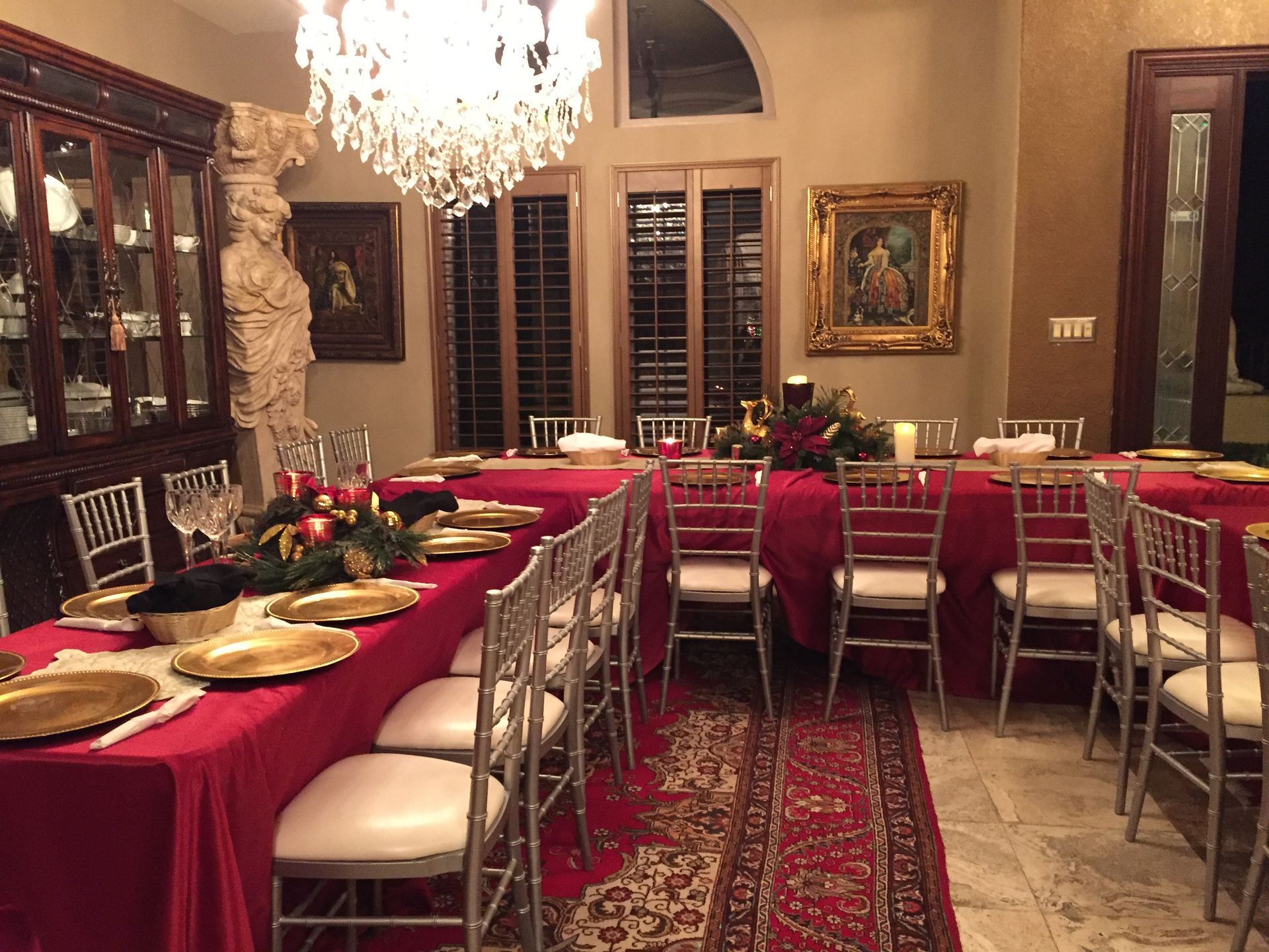 A dining room with a long table and chairs set for a party.
